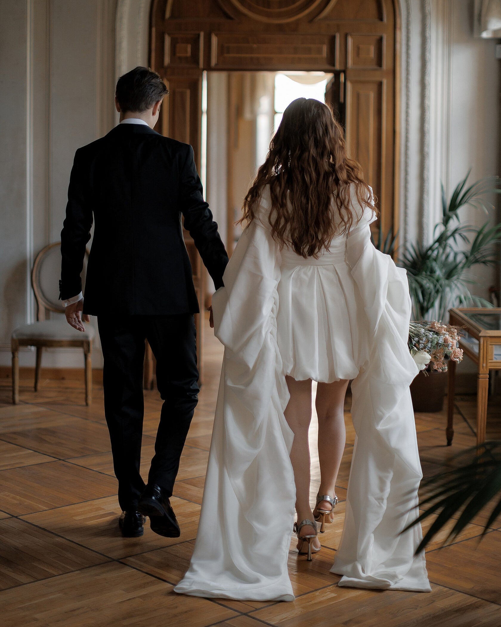 Chic mini wedding dress with long draped sleeves and an elegant bubble skirt