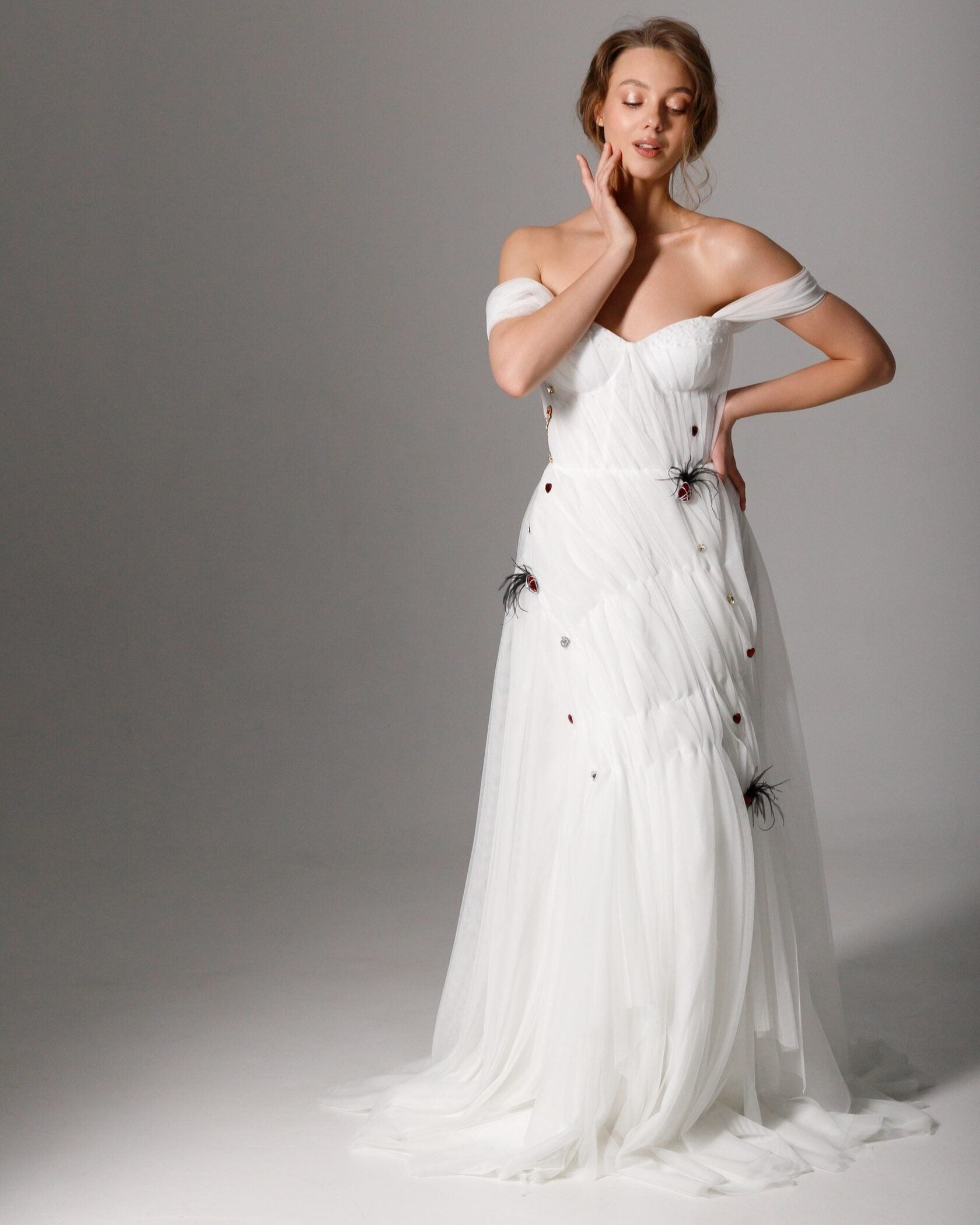 Draped off-the-shoulder corset wedding dress with a sculpted fit and soft tulle skirt