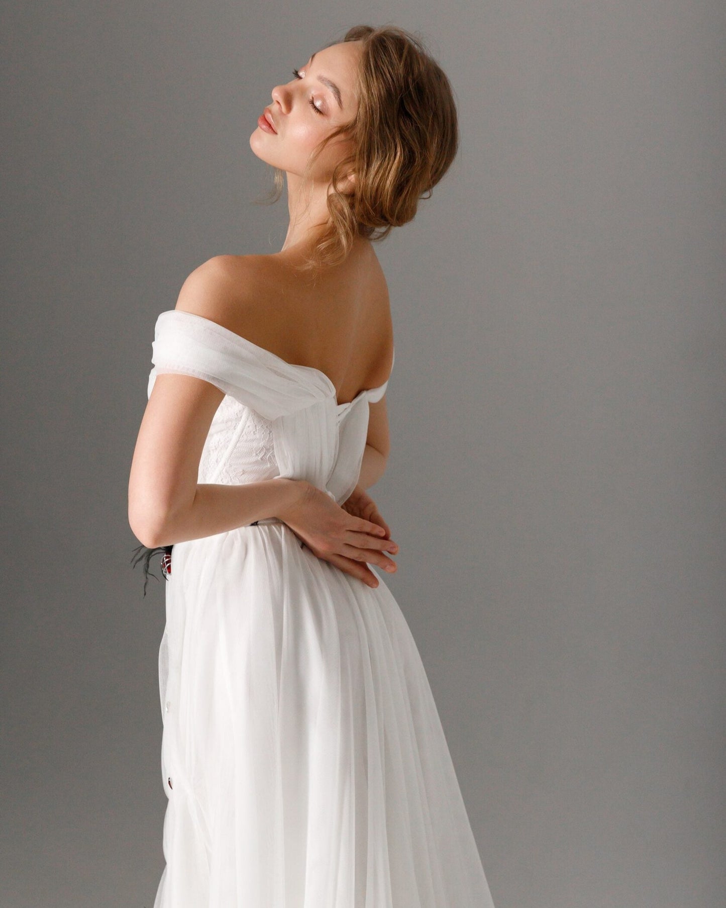 Modern romantic bridal gown featuring a structured corset and soft, flowing layers