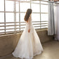 Elegant sheer wedding gown featuring subtle sparkle and a modern minimalist design
