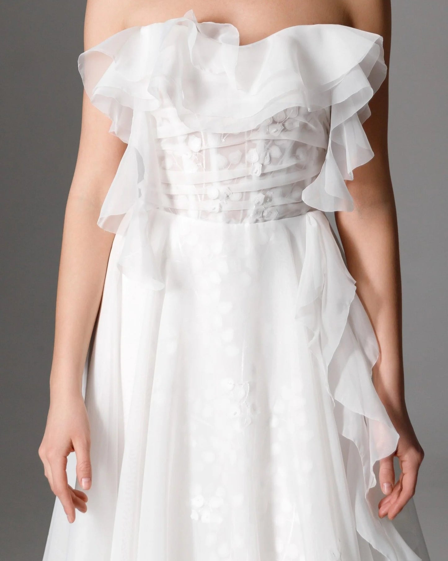 Flowing layered tulle wedding dress with intricate floral embroidery and cascading ruffle details