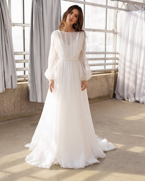 Flowing organza wedding dress with sheer sleeves and a voluminous silhouette