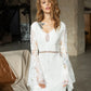 Elegant bohemian lace wedding dress featuring a V-neckline and long flared sleeves