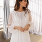 Long sleeve flowy wedding gown with a delicate round neckline and open-back slip dress