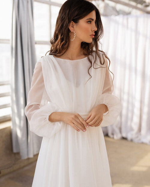 Long sleeve flowy wedding gown with a delicate round neckline and open-back slip dress