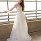 Minimalist glitter long sleeve wedding dress with sheer overlay and flowing A-line silhouette