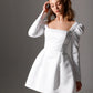 Modern mini bridal dress with delicate pearl details and a soft sheen satin finish