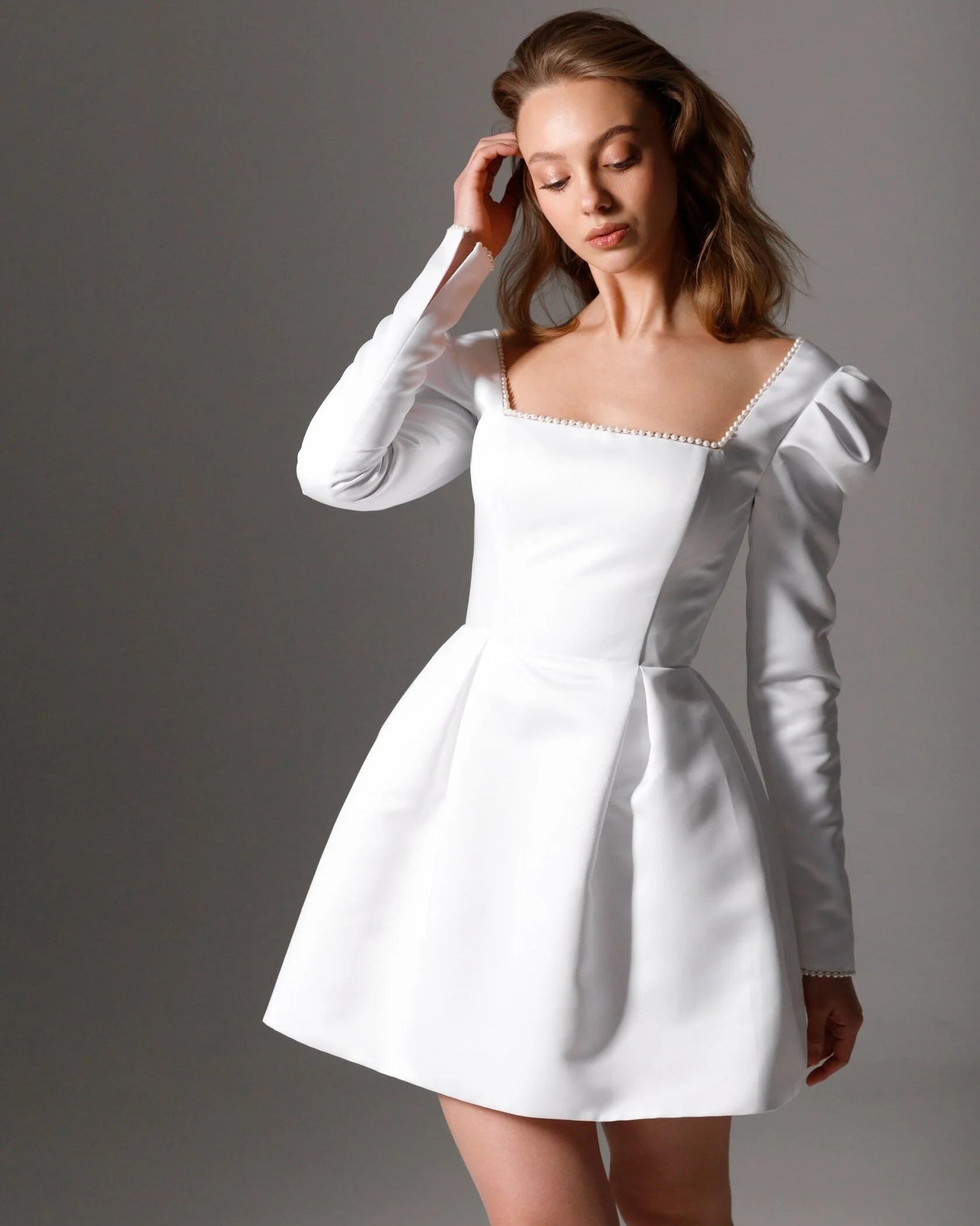 Modern mini bridal dress with delicate pearl details and a soft sheen satin finish