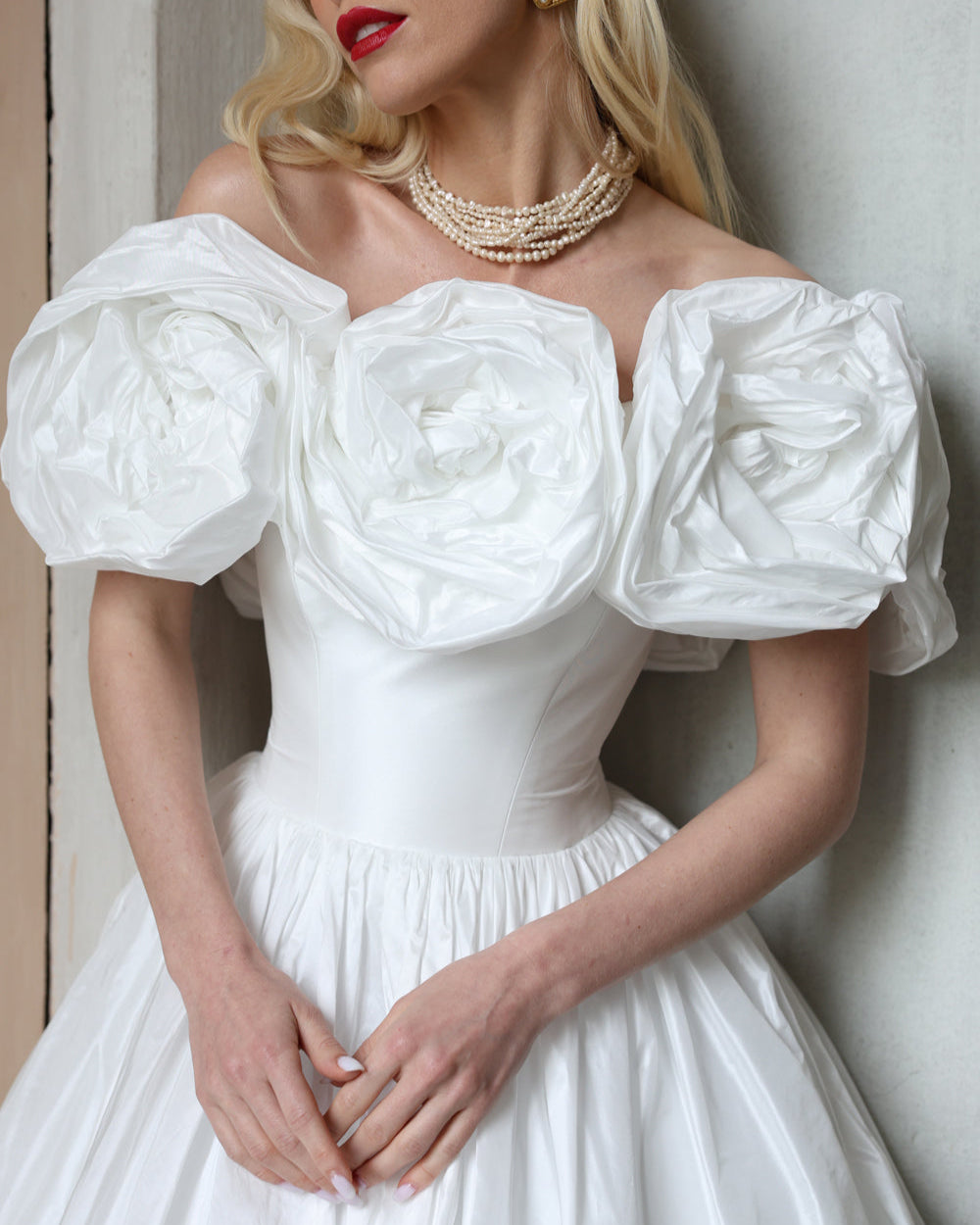 Off-the-shoulder taffeta ball gown wedding dress with sculptural floral details