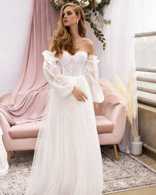 Romantic lace boho wedding gown featuring an intricate hand-embellished corset bodice