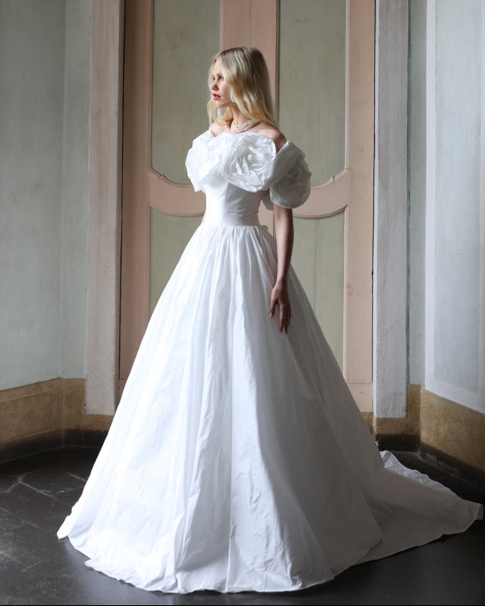 Romantic ball gown bridal dress with oversized floral embellishments and voluminous draping