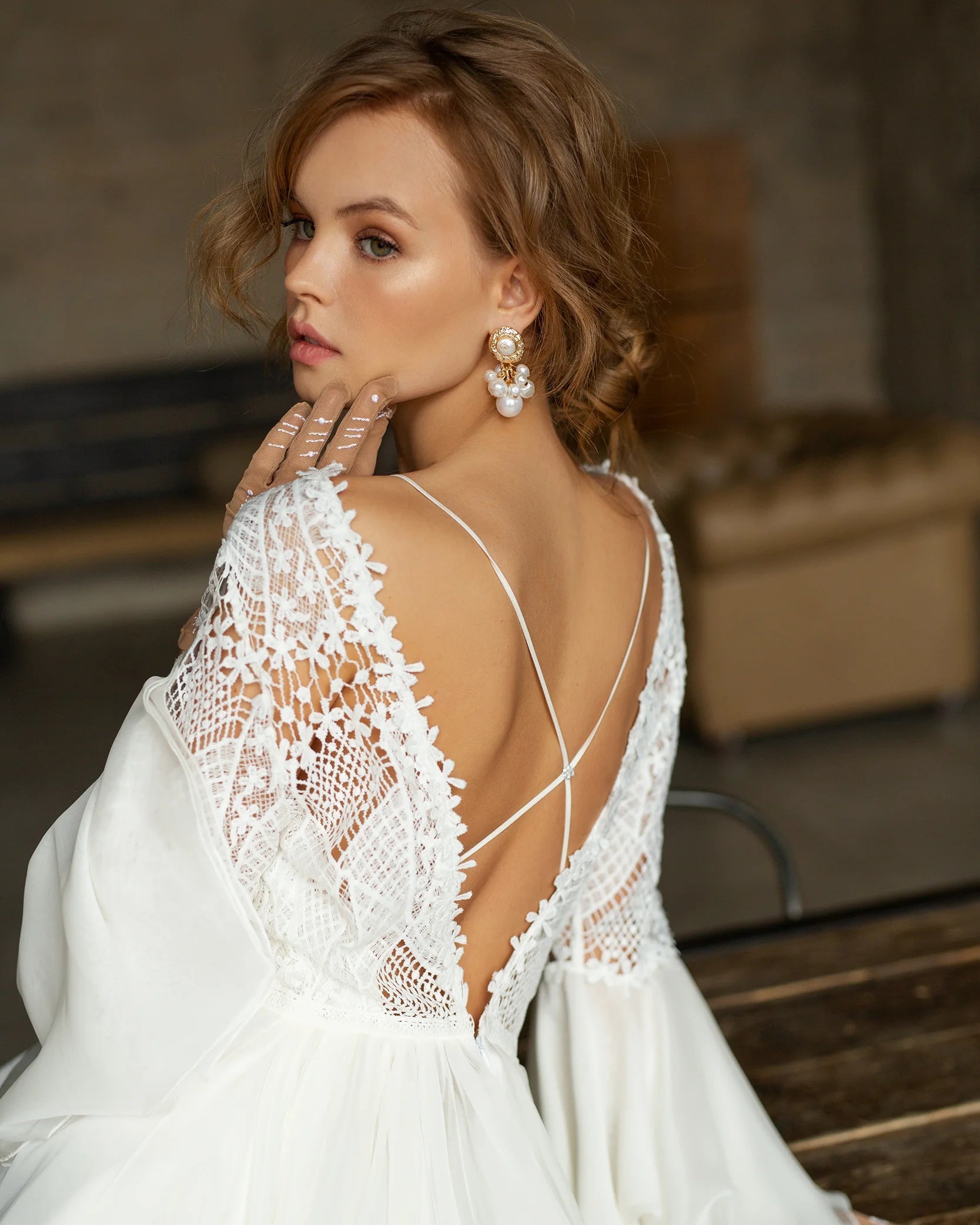 Romantic boho wedding gown featuring an intricate high-neck lace bodice and flared sleeves