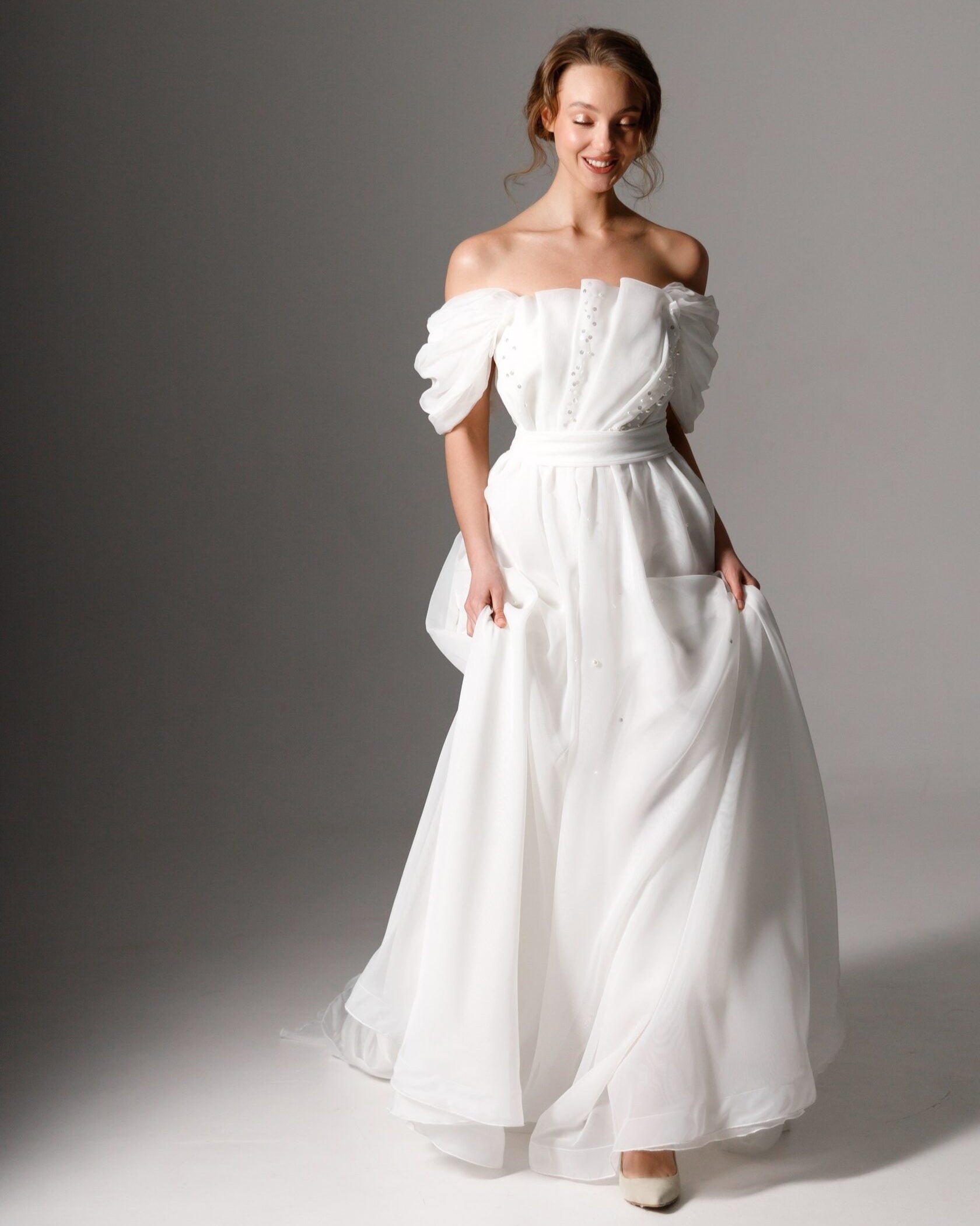 Romantic organza wedding gown featuring delicate pearl embellishments and soft draping