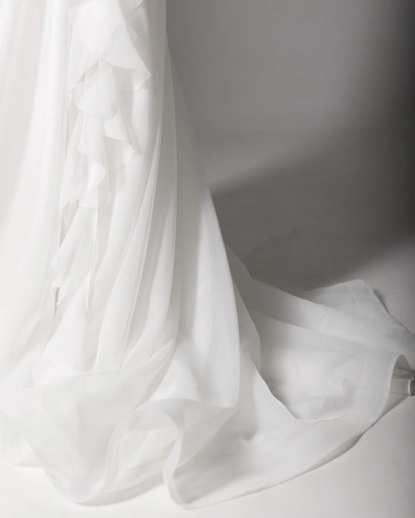 Soft ruffled organza bridal gown with delicate hand-sewn floral embroidery and a dreamy design